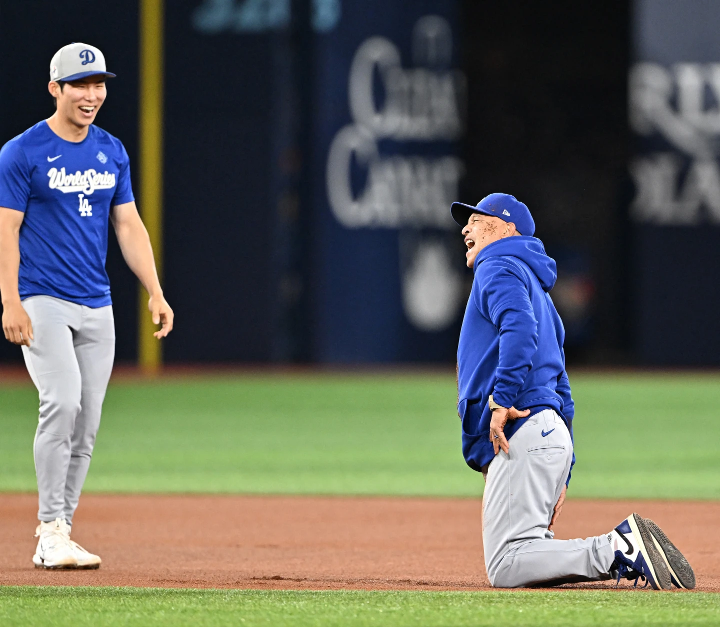道奇隊總教練羅伯茲(Dave Roberts)在G6開打前官方練習時與金慧成(左)賽跑卻摔倒。法新社