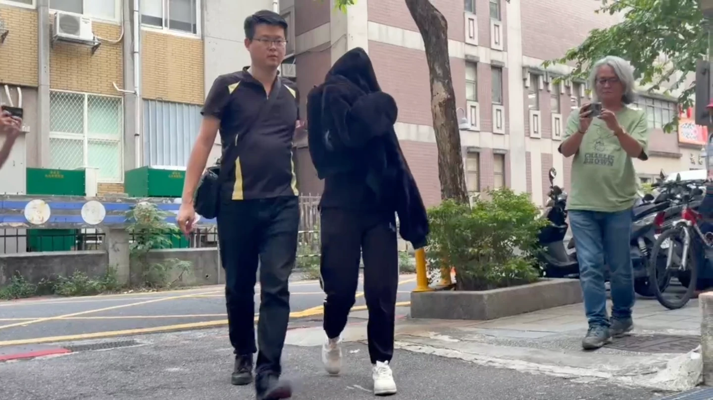 黃牛票集團首腦張依萍(中)昨被移送北檢複訊時,遮臉躲鏡頭。民眾提供